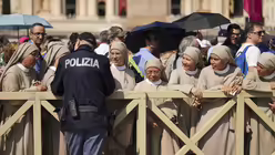 Nonnen aus Spanien und Südamerika unterhalten sich mit einem Polizisten, während sie in der Schlange stehen / © Francisco Seco/AP (dpa)