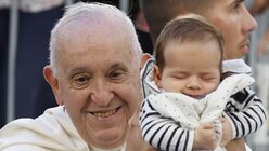 Papst Franziskus hält ein Baby hoch, als er zur Messe im Velodrome-Stadion eintrifft / © Sebastien Nogier/EPA Pool/AP/ (dpa)