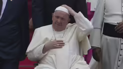 Indonesien, Tangerang: Papst Franziskus in seinem Rollstuhl hält seinen Pileolus bei der Ankunft während einer offiziellen Begrüßungszeremonie am Soekarno-Hatta International Airport in Tangerang / © Achmad Ibrahim (dpa)