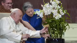 Hwang Yu-Ning, Chief Executive Officer des Singapore's National Parks Board, überreicht Papst Franziskus eine "Dendrobium His Holiness Pope Francis", eine speziell gezüchtete Orchideenart, die nach ihm benannt wurde, im Parlamentsgebäude in Singapur / © Gregorio Borgia/AP/ (dpa)