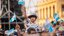 Ein kleiner Junge schwenkt eine kleine argentinische Nationalfahne in der Menschenmenge. / © Mariano Campetella (KNA)