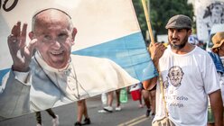 Ein Mann trägt eine argentinische Fahne mit dem aufgedruckten Konterfei von Papst Franziskus. / © Mariano Campetella (KNA)