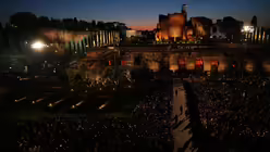 Menschen warten vor dem Kolosseum auf die "Via Crucis", den katholischen Karfreitags-Kreuzweg mit Fackeln, an dem auch Papst Leo XIV. teilnimmt und der symbolisch die Schritte Jesu Christi bis zu seiner Kreuzigung auf dem Kalvarienberg in Jerusalem nachzeichnet. / &copy; Alessandra Tarantino/AP/dpa (dpa)