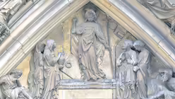 Auf der Südseite der Kathedrale zum Roncalliplatz hin befindet sich im Tympanon des Mittelportals die Szene, wie Jesus aus dem Grab aufersteht. Der Künstler lässt hier die Frauen, die zum Grab kommen, sowie den Apostel Petrus, wie es den Anschein hat, Zeugen der Auferstehung werden. / © Robert Boecker (privat)