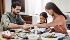 Dankbarkeit einer Familie beim Tischgebet / &copy; PeopleImages (shutterstock)