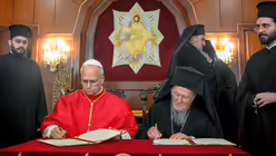 Papst Leo XIV. und Bartholomaios I., griechisch-orthodoxer Ökumenischer Patriarch von Konstantinopel und Ehrenoberhaupt der Weltorthodoxie, unterzeichnen eine gemeinsame Erklärung am 29. November 2025 in der Patriarchatspalast in Istanbul (Türkei). / © Vatican Media/Romano Siciliani (KNA)