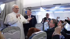 Papst Leo XIV. begrüßt am 27. November 2025 Reporter an Bord eines Flugzeugs auf dem Weg nach Ankara zu einer sechstägigen Reise in die Türkei und den Libanon. / © Domenico Stinellis/AP (dpa)