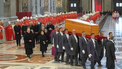 Der Sarg des verstorbenen emeritierten Papstes Benedikt XVI. durch den Petersdom getragen. In den vatikanischen Grotten wurde er in der ehemaligen Gruft von Papst Johannes Paul II. unter der Basilika beigesetzt wird. (VM)