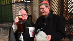 Zum Dank für die Andacht im Dom überreicht Bruder Dirk Kardinal Woelki einen Stein aus dem Hohlweg, an dem Engelbert ermordet wurde, sowie eine Flasche bergisches Bier. / © Beatrice Tomasetti (DR)