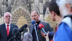 Msgr. Robert Kleine erklärt, dass die Steine vom Dom sind. / © Melanie Trimborn (DR)