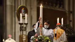 Judith Maurer ist gerne nah dran am heiligen Geschehen - hier stellt sie die Osterkerze in ihren Ständer. / © Beatrice Tomasetti (DR)