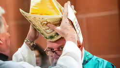Kardinal Marx wird vor der Eucharistiefeier im Frankfurter Dom die Mitra abgenommen  / &copy; Andreas Arnold (dpa)