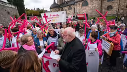 Kardinal Reinhard Marx (m.) mit Demonstrantinnen der Katholischen Frauengemeinschaft Deutschlands / &copy; Frank Rumpenhorst (dpa)