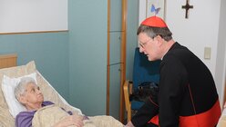 Kardinal Woelki - hier am Bett einer Hospizpatientin - betont immer wieder die Wichtigkeit von Sterbebegleitung (Archivbild). / © Beatrice Tomasetti (DR)