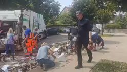 Helfer werfen Sperrmüll in ein Müllauto vor der Kirche St. Martin in Rheinbach-Flerzheim. / © Harter (Erzbistum Köln)
