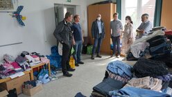 Im Haus der Begegnung in Leverkusen zeigen Gemeindemitglieder Kardinal Woelki die spontan eingerichtete Kleiderkammer. / © Kathrin Becker (Kirchenzeitung Koeln)