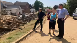 Eine Anwohnerin der Gemeinde St. Petrus und Paulus berichtet Kreisdechant Hans-Josef Lahr und Kardinal Woelki von den Schäden der Unwetterkatastrophe in Swisttal-Odendorf. / © Bues (Erzbistum Köln)