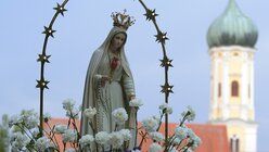 Gläubige tragen bei Ziemetshausen (Bayern) bei der Wallfahrtskirche Maria Vesperbild bei der Lichterprozession eine Marienstatue.  / © Stefan Puchner (dpa)