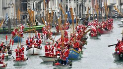 Menschen in Weihnachts-Kostümen fahren in Ruderbooten auf dem Canal Grande in Venedig / © Luigi Costantini (dpa)