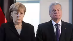 In Trauer: Merkel und Gauck / &copy; Wolfgang Kumm (dpa)
