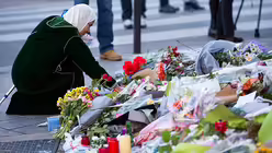 Frau legt Blumen vor dem Restaurant "Petit Cambodge" nieder / &copy; Marius Becker (dpa)
