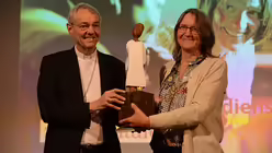 Nach seiner Laudatio auf Maria Oberhofer überreicht Erzbischof Schick der ersten Preisträgerin des AGIAMONDO-Engagementpreises eine kleine Königsfigur von Ralf Knoblauch. / © Beatrice Tomasetti (DR)