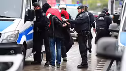 Polizisten mit einem Demonstranten (DR)