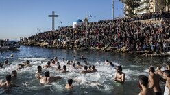 Orthodoxe Gläubige schwimmen in Griechenland zu einem hölzernen Kreuz (dpa)