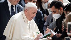 Papst Franziskus gibt Teilnehmern der Generalaudienz ein Autogramm / © Cristian Gennari/Romano Siciliani (KNA)