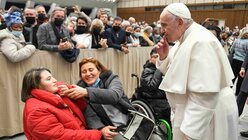 Papst Franziskus grüßt eine Frau im Rollstuhl mit einem Luftkuss während der Generalaudienz. / © Vatican Media/Romano Siciliani (KNA)