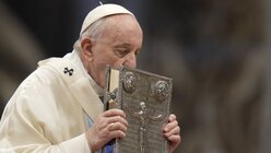 Papst Franziskus küsst das Heilige Buch / © Andrew Medichini (dpa)
