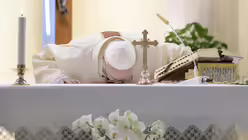 Papst Franziskus k&uuml;sst den Altar w&auml;hrend eines Gottesdienstes am 30. April 2020 in der Kapelle Santa Marta im Vatikan. / &copy; Vatican Media/Romano Siciliani (KNA)