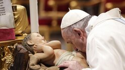 Papst Franziskus küsst eine Statue des Jesuskindes / © Giuseppe Lami (dpa)