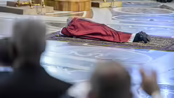 Papst Franziskus liegt betend auf dem Boden des Petersdoms / &copy; Cristian Gennari (KNA)