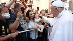 Papst Franziskus segnet ein Baby w&auml;hrend des Besuchs der Roma-Siedlung Lunik IX / &copy; Vatican Media/Romano Siciliani (KNA)