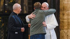 Papst Franziskus umarmt eine Teilnehmerin beim Zusammentreffen mit Armen in der Basilika Santa Maria degli Angeli / © Riccardo De Luca (dpa)