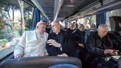 Papst Franziskus unterhält sich mit Kardinal Tarcisio Bertone im Bus / © Romano Siciliani (KNA)