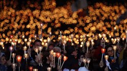 Gläubige stehen in Fatima mit Kerzen vor dem Heiligtum von Fatima. / © Alessandra Tarantino (dpa)