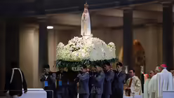 Die Marienstatue wird durch die Menge der Pilger getragen.  / © Armando Franca (dpa)