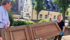 Pfarrer José Pérez Pérez und Kardinal Woelki helfen beim Ausräumen des Kellers der Kirche Herz-Jesu / © Bues (Erzbistum Köln)