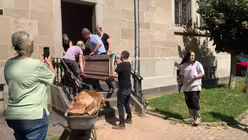 Pfarrer José Pérez Pérez und Kardinal Woelki helfen beim Ausräumen des Kellers der Kirche Herz-Jesu / © Bues (Erzbistum Köln)