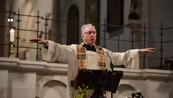 Pfarrer Rainer Fischer erklärt, dass man Frieden spüren müsse, und macht vor, was er damit meint. / © Tomasetti (DR)