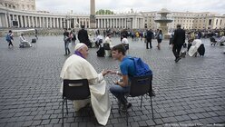 Auf dem Petersplatz nimm Papst Franziskus Jugendlichen überraschend die Beichte ab.  / © Osservatore Romano Handout (dpa)