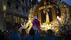Ein kleines Mädchen wird in Madrid bei der Prozession zu Ehren der Jungfrau Paloma zum Gemälde der Jungfrau hochgehoben.  / © Francisco Seco (dpa)