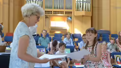 Schulleiterin Gertrud Trebels ehrt Mila für ihre Teilnahme an der Flöten-AG / © Beatrice Tomasetti (DR)