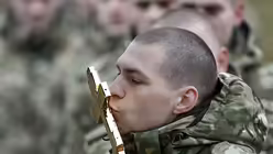 Soldaten einer Spezialeinheit des weißrussischen Innenministeriums küssen ein Kreuz / © Sergei Grits (dpa)