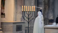 Sr. Sarah-Franziska zündet zur Messfeier den siebenarmigen Leuchter an. / © Beatrice Tomsetti (DR)