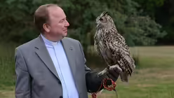 Stadtdechant Robert Kleine mit dem Uhu Elsa. / © Beatrice Tomasetti (DR)