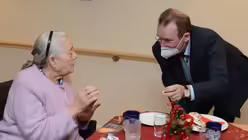 Stadtsuperintendent Seiger im Gespräch mit einer Bewohnerin im Wohnbereich "Chlodwigsplatz" des "Veedelshauses".  / © Beatrice Tomasetti (DR)