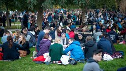 Taizé-Teilnehmer sitzen im Park.  / © Mercedes Herran (KNA)